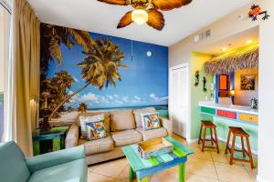 a living room with a couch and a palm tree mural at Destin West Resort - Gulfside V305 in Fort Walton Beach