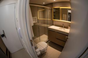 a bathroom with a toilet and a glass shower at Rooftop 470 - Novíssimo Flat Boa Viagem in Recife