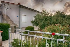 a white fence in front of a house at Apartment Vacation Rental Near Pula in Loborika