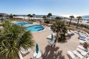 un complejo con piscina, sillas y playa en Emerald Isle 0107, en Pensacola Beach