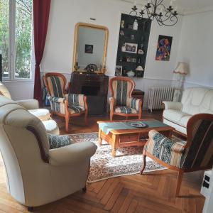 ein Wohnzimmer mit Möbeln und einem Spiegel in der Unterkunft VILLA DE SOUZA in Bouillé-Loretz