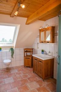 a bathroom with a sink and a toilet and a window at Haus im Felde Whg 5 in Fehmarn