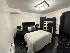 a bedroom with a bed with a black and white blanket at Centenary Apartments in Bradford