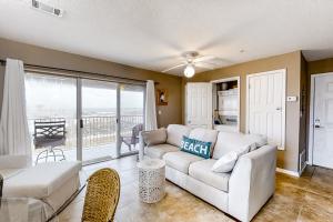 a living room with a white couch and a balcony at Sunset Harbour Villas 1-111 in Navarre