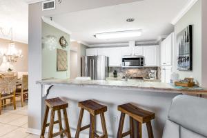 a kitchen with a counter and stools in a room at South Harbour 04C in Pensacola Beach
