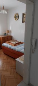 ein kleines Schlafzimmer mit einem Bett und einem Spiegel in der Unterkunft D-apartmani in Bijeljina