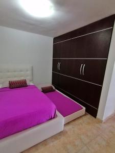 a bedroom with a large bed with purple sheets at Lo mejor de isla Margarita in Pampatar