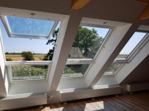 a room with three large windows in a house at Haus im Felde Whg 5 in Fehmarn