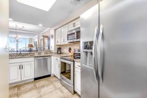 a kitchen with stainless steel appliances and white cabinets at Pearl 1305 in Navarre