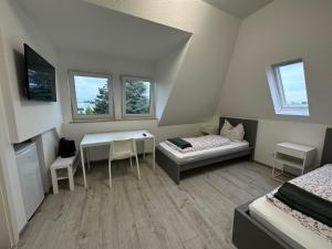 Schlafzimmer mit einem Schreibtisch, einem Bett und einem Tisch in der Unterkunft Apart-Hotel Rheinischer Hof Dormagen in Dormagen