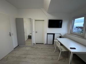 ein weißes Zimmer mit einem Tisch und einem Fenster in der Unterkunft Apart-Hotel Rheinischer Hof Dormagen in Dormagen
