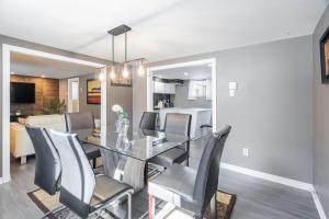 Joe's bnb CITQ 3I8I25 في Mascouche: غرفة طعام وغرفة معيشة مع طاولة وكراسي زجاجية