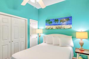 a bedroom with a white bed and blue walls at Windemere 0302 in Perdido Key