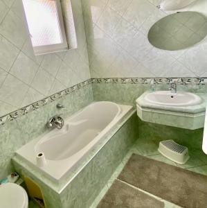 a bathroom with a tub and a sink at Dharma Horse Shelter Bungalows & Farmping in Siófok