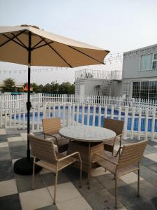 a table and chairs with an umbrella on a patio at مزرعة واستراحة المنامة 