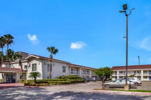 - un parking en face d'un immeuble avec des palmiers dans l'établissement Motel 6-Baytown, TX - Garth Rd, à Baytown