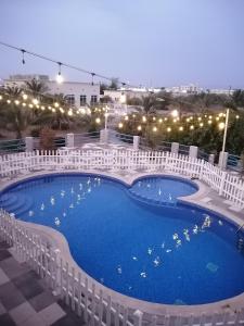 una gran piscina con vallas blancas alrededor en مزرعة واستراحة المنامة, 