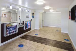 um corredor com uma televisão e um piso de azulejo em Motel 6-Baytown, TX - Garth Rd em Baytown