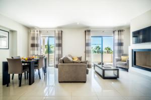 ein Wohnzimmer mit einem Tisch und einem Esszimmer in der Unterkunft Fabulous 2 bedroom apartment Pine Hills in Vilamoura