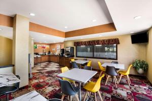 Quality Inn في دي موين: لوبي بطاولات وكراسي صفراء في كفتريا