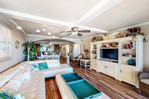 a living room with a white couch and a tv at Surf Dweller 704 in Fort Walton Beach
