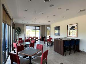 un comedor con mesas, sillas y ventanas en Comfort Suites Jackson-Cape Girardeau en Jackson