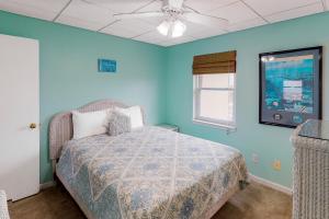 um quarto com uma cama e uma ventoinha de tecto em Treehouse Townhome em Pensacola Beach