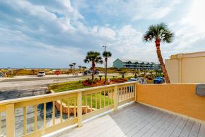 a balcony with palm trees and a street at Treehouse Townhome in Pensacola Beach