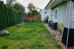 a yard next to a house with a fence at Fresh And Cozy Little House 45km In Täby in Stockholm