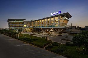 een groot gebouw met een bord erop bij Radisson Blu Hotel Riyadh Convention and Exhibition Center in Riyad