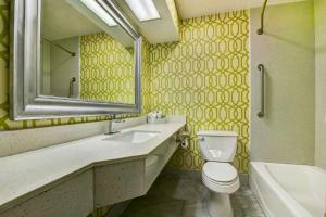 a bathroom with a sink and a toilet and a mirror at Motel 6 Atlanta, Ga - Midtown in Atlanta