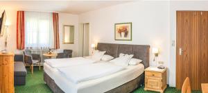 ein Schlafzimmer mit einem großen weißen Bett in einem Zimmer in der Unterkunft Hotel Steffl Garni in Ruhpolding