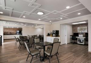 a meeting room with a table and chairs and a piano at SureStay Plus by Best Western Pigeon Forge in Pigeon Forge