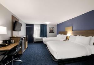 a hotel room with two beds and a desk at SureStay Plus by Best Western Pigeon Forge in Pigeon Forge