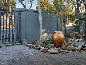 a large vase sitting in front of a fence at 51on Church in Welkom