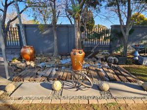 a garden with a statue of a bike and vases at 51on Church in Welkom