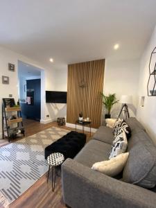 uma sala de estar com um sofá cinzento e uma mesa em Luxury Spacious Renovated Townhouse em Grantham