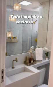 a bathroom with a sink and a mirror at Apartamento Jacarepagua in Rio de Janeiro