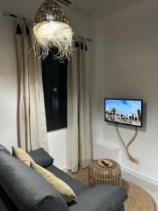 a living room with a couch and a tv at Plaza de la fuente Granadilla de Abona Tenerife sur Only Adults con terraza privada in Granadilla de Abona