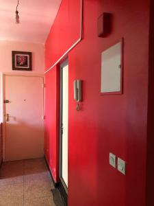 a hallway with a red wall and a door at Heart appartement Al massira in Agadir