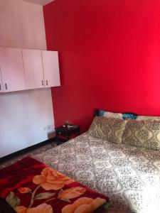 a bedroom with a bed with a red wall at Heart appartement Al massira in Agadir