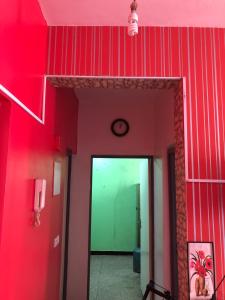 a hallway with red walls and a clock on the wall at Heart appartement Al massira in Agadir