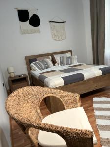 - une chambre avec un lit et un fauteuil en rotin dans l'établissement Bonne Nuit Terracina, à Terracine