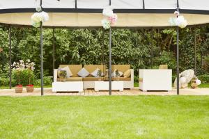 una glorieta con sofás y flores. en Hotel Gutsgasthof Stangl, en Neufarn