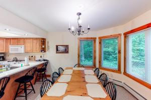 a dining room with a long table and chairs at Summit Solitude & Latitude Adjustment in Jay