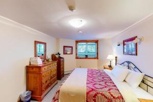 a bedroom with a bed and a dresser and windows at Summit Solitude & Latitude Adjustment in Jay