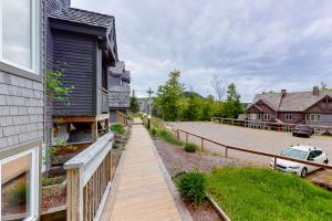 a house with a wooden walkway next to a driveway at Summit Solitude & Latitude Adjustment in Jay