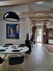 un soggiorno con 2 tavoli, sedie e un dipinto di Senamiescio apartamentai Kaune a Kaunas