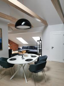 a dining room with a white table and chairs at Charming Apartment in Kaunas Old Town with Balcony in Kaunas
