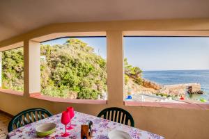 a table with a view of the ocean through windows at Casa Stecchi in Capoliveri